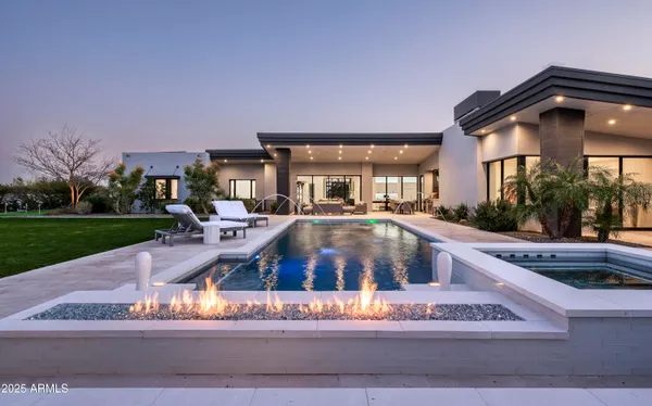 a view of a house with a swimming pool and sitting area