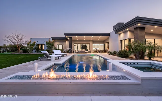a view of a house with a swimming pool and sitting area