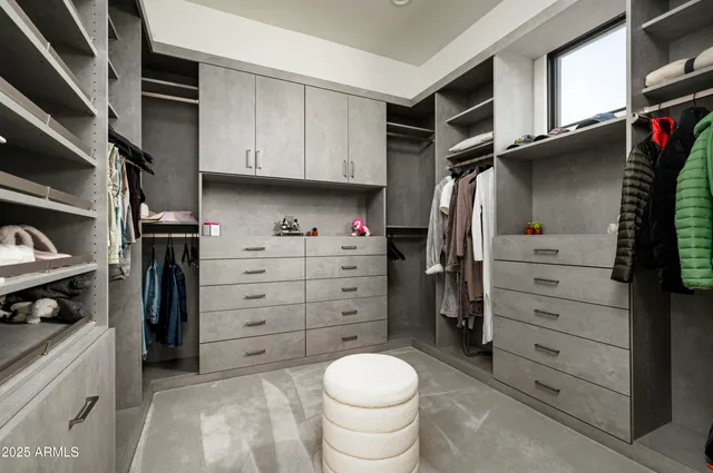 a view of walk in closet with clothes and shoes