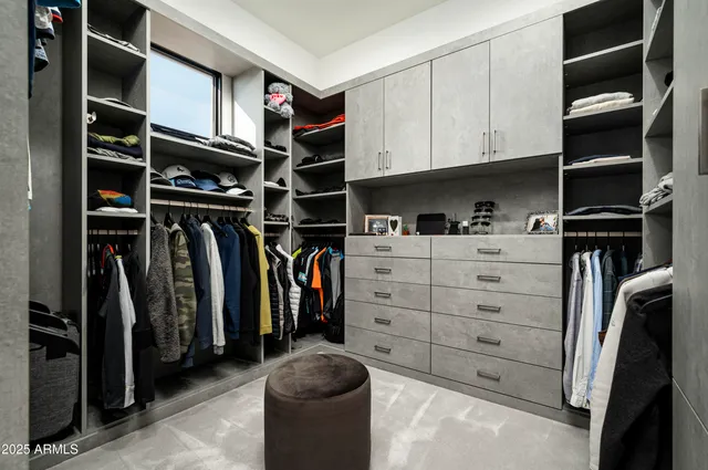 a view of walk in closet with clothes and shoes
