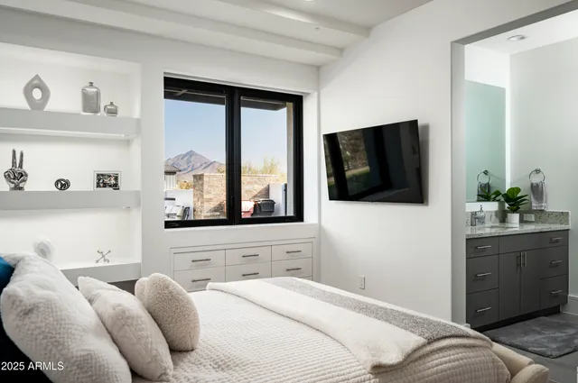 a bedroom with a bed and a flat tv screen on dresser