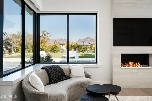 a living room with furniture a flat screen tv and a large window