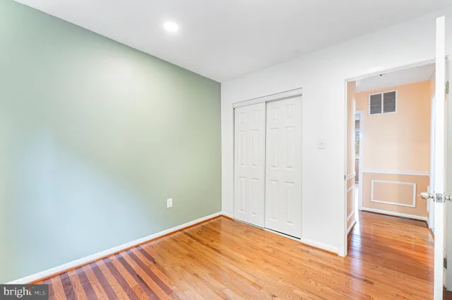 a view of empty room with wooden floor