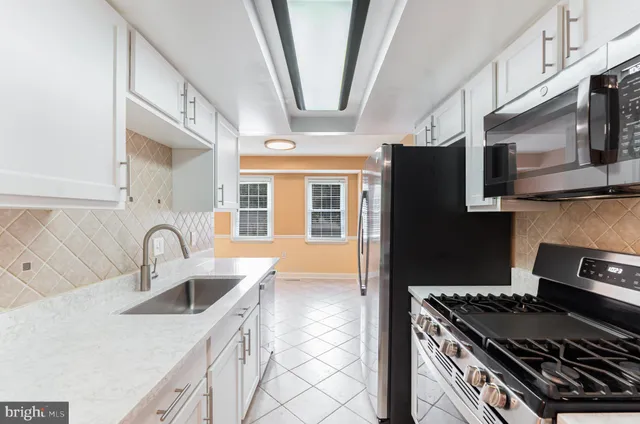 a kitchen with stainless steel appliances granite countertop a sink and a stove