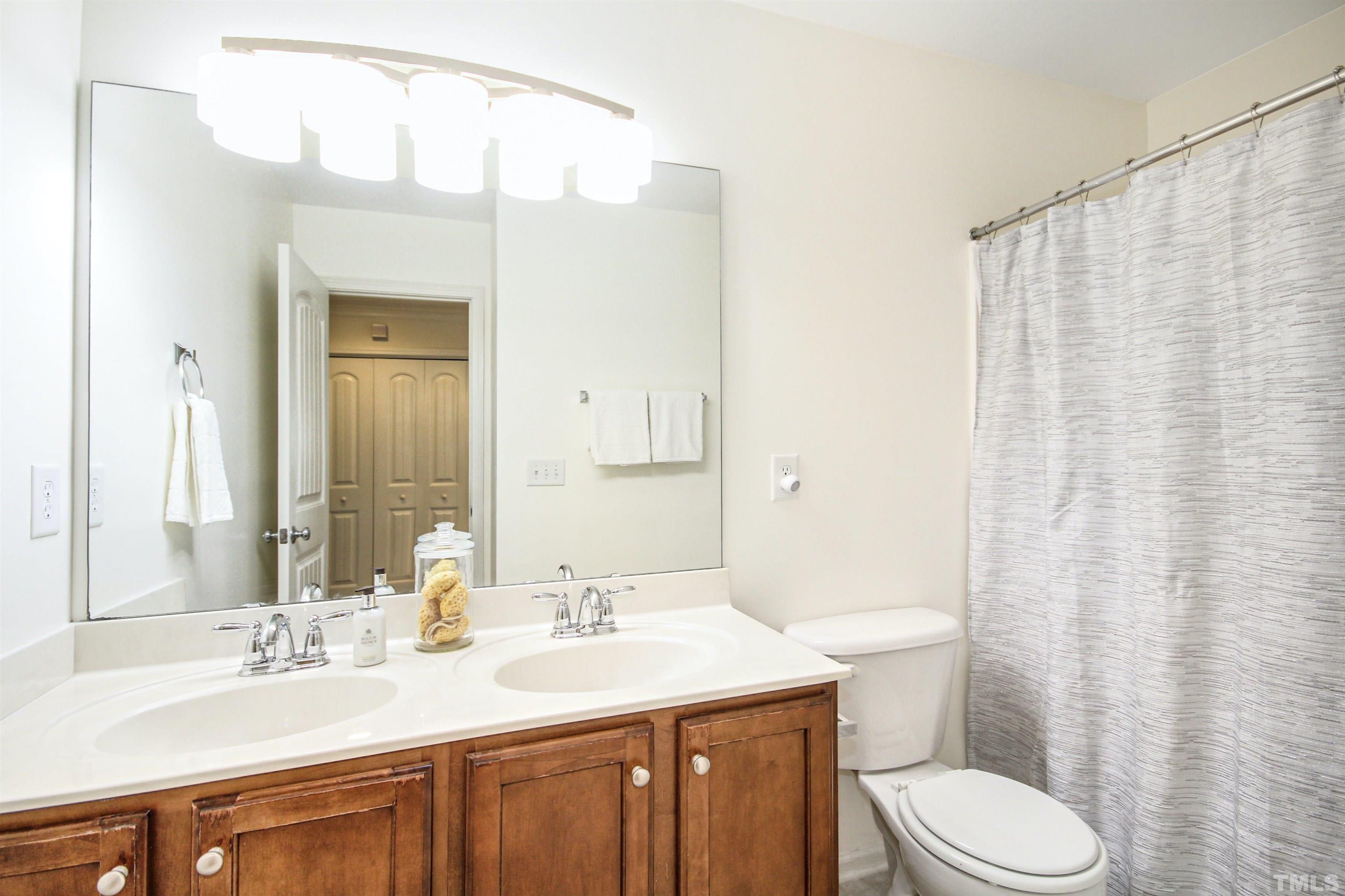 4611 Altha Street Raleigh, NC 27606 - Photo 15 of 19 a bathroom with a sink a toilet and shower curtain