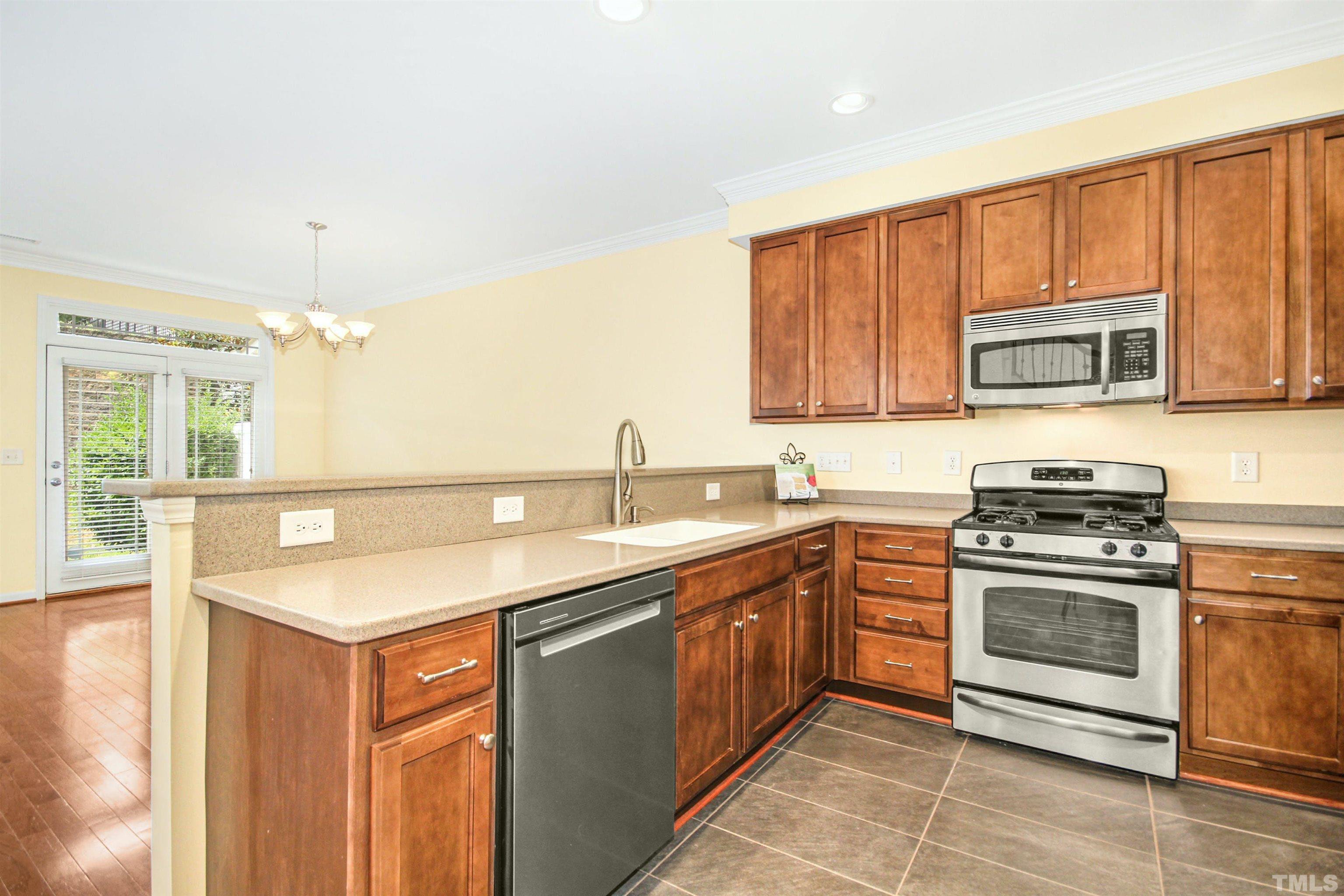 4611 Altha Street Raleigh, NC 27606 - Photo 6 of 19 a kitchen with stainless steel appliances granite countertop a sink stove and microwave