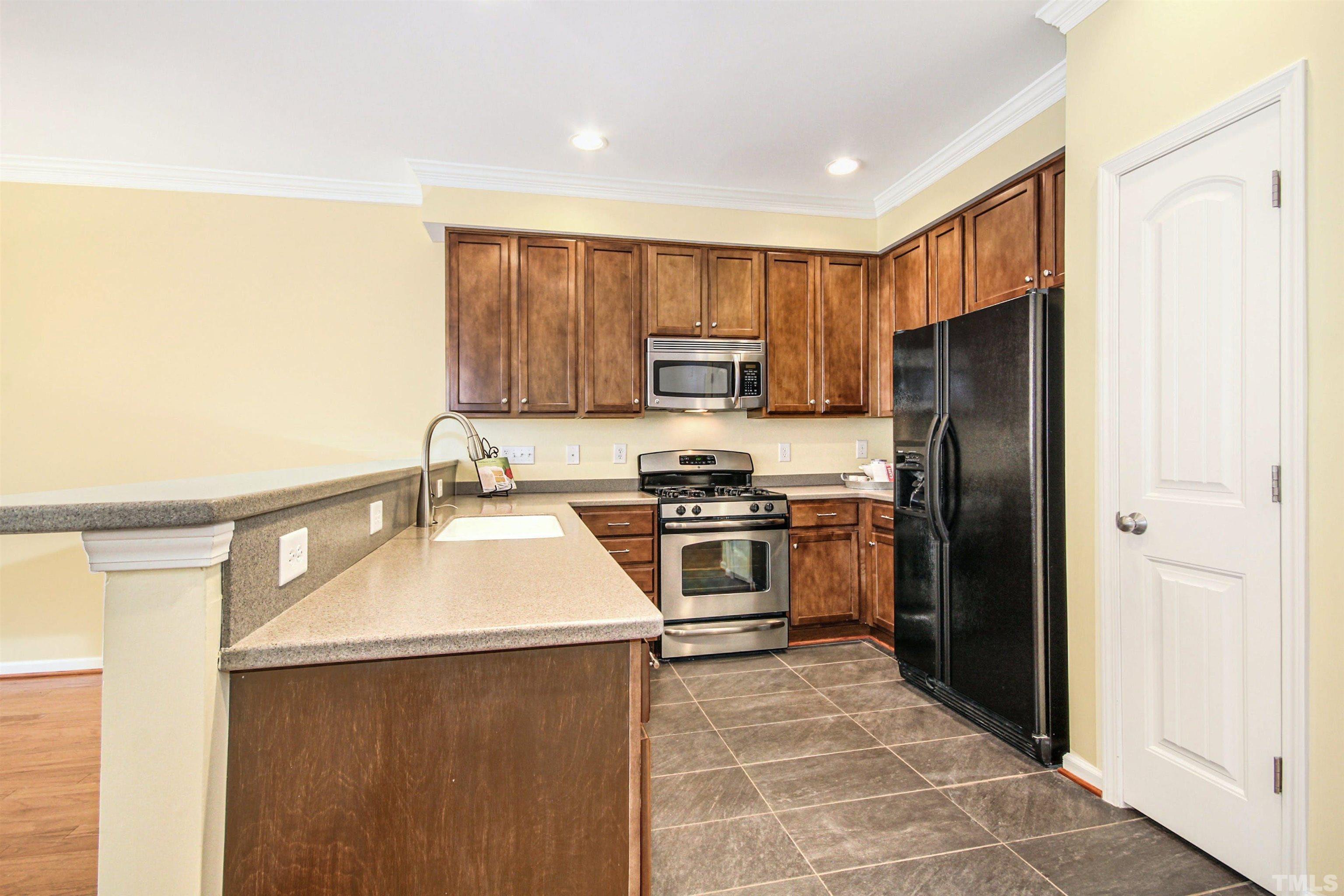 4611 Altha Street Raleigh, NC 27606 - Photo 7 of 19 a kitchen with a refrigerator sink and stove