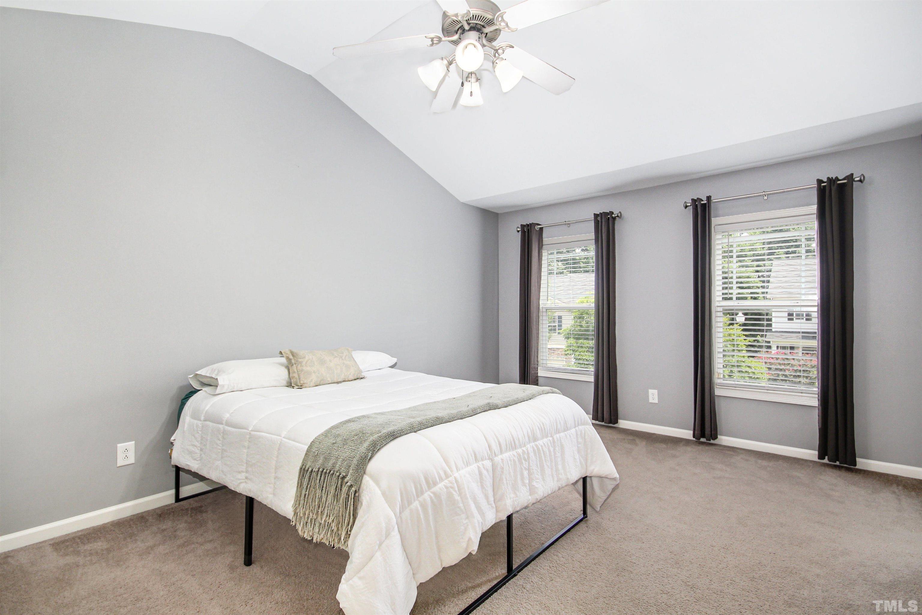 4611 Altha Street Raleigh, NC 27606 - Photo 8 of 19 a spacious bedroom with a bed and a chandelier