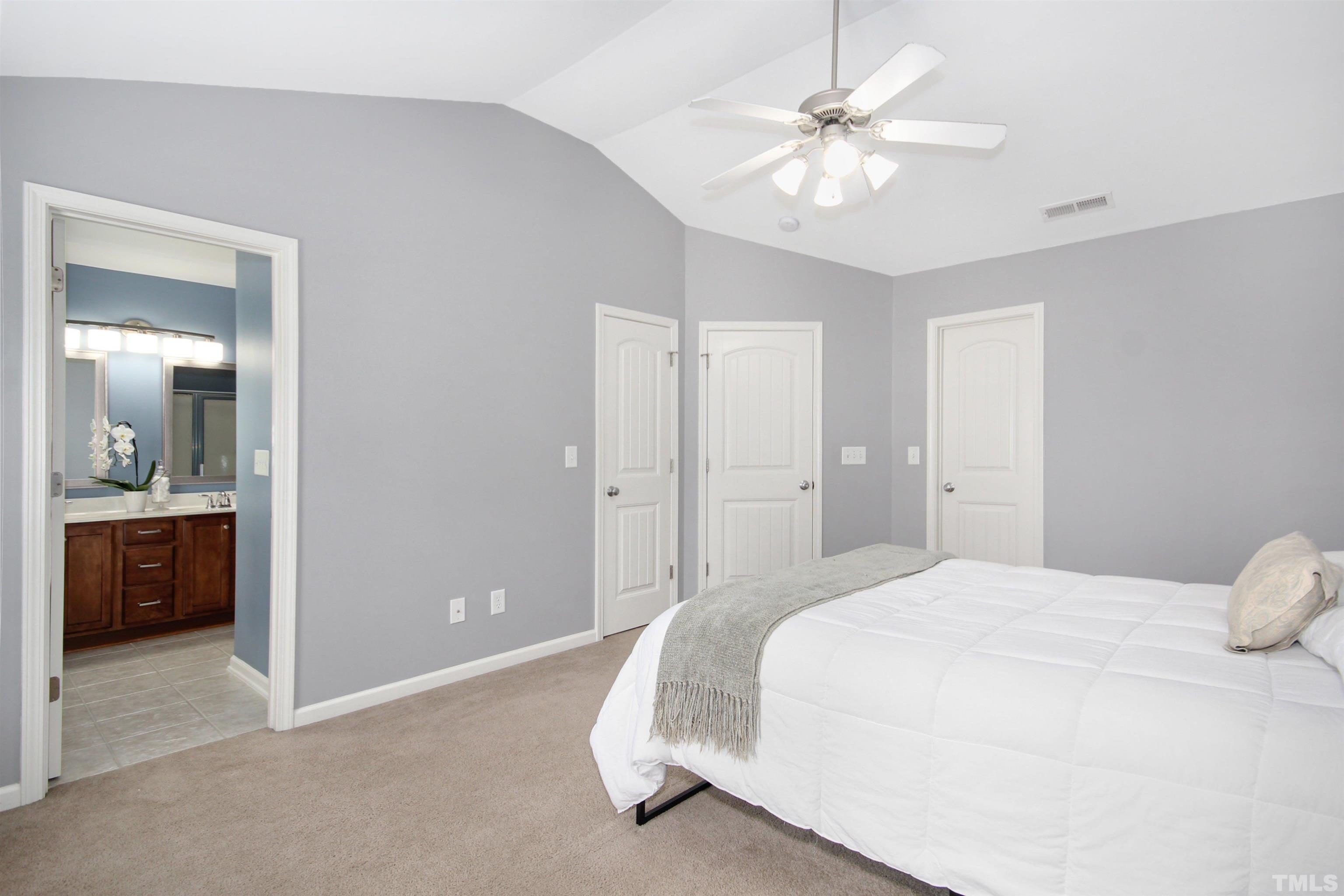 4611 Altha Street Raleigh, NC 27606 - Photo 9 of 19 a spacious bedroom with a bed and a chandelier