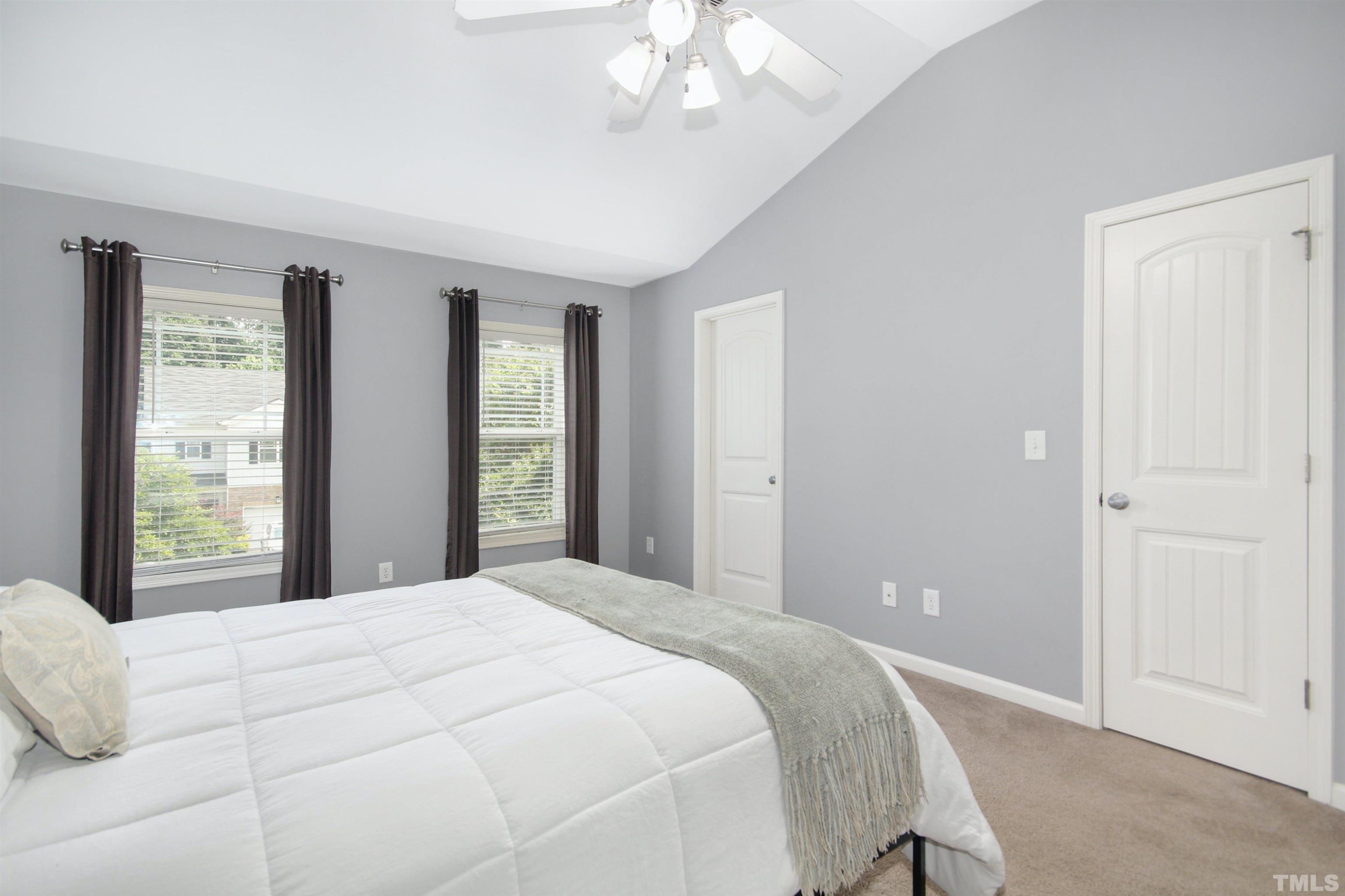 4611 Altha Street Raleigh, NC 27606 - Photo 10 of 19 a bedroom with a large bed and a chandelier