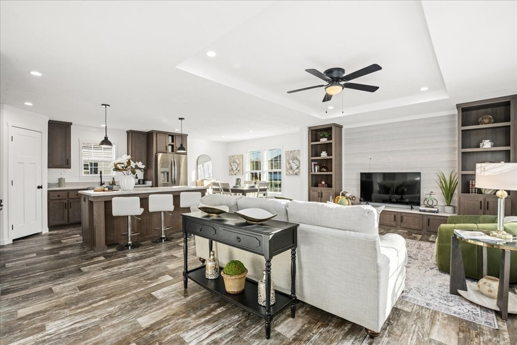 6 Berry Farms Road, Unit 63 Sturbridge, MA 01566 - Photo 3 of 17 a living room with stainless steel appliances kitchen island granite countertop furniture a fireplace wooden floor and a rug