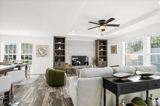 a living room with furniture a fireplace and a chandelier