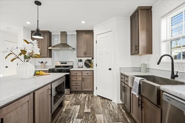 a kitchen with stainless steel appliances granite countertop a sink stove and refrigerator