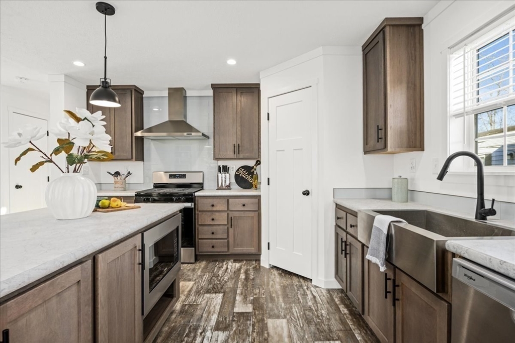 6 Berry Farms Road, Unit 63 Sturbridge, MA 01566 - Photo 8 of 17 a kitchen with stainless steel appliances granite countertop a sink stove and refrigerator