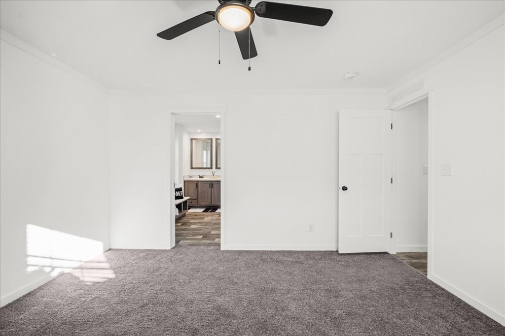 6 Berry Farms Road, Unit 63 Sturbridge, MA 01566 - Photo 9 of 17 an empty room with chandelier fan and windows