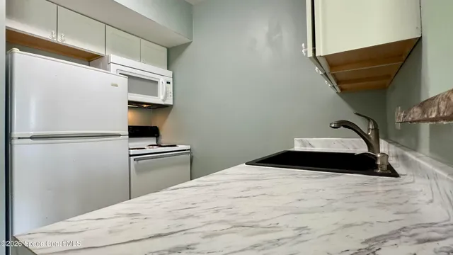 a bedroom with a bed and a refrigerator