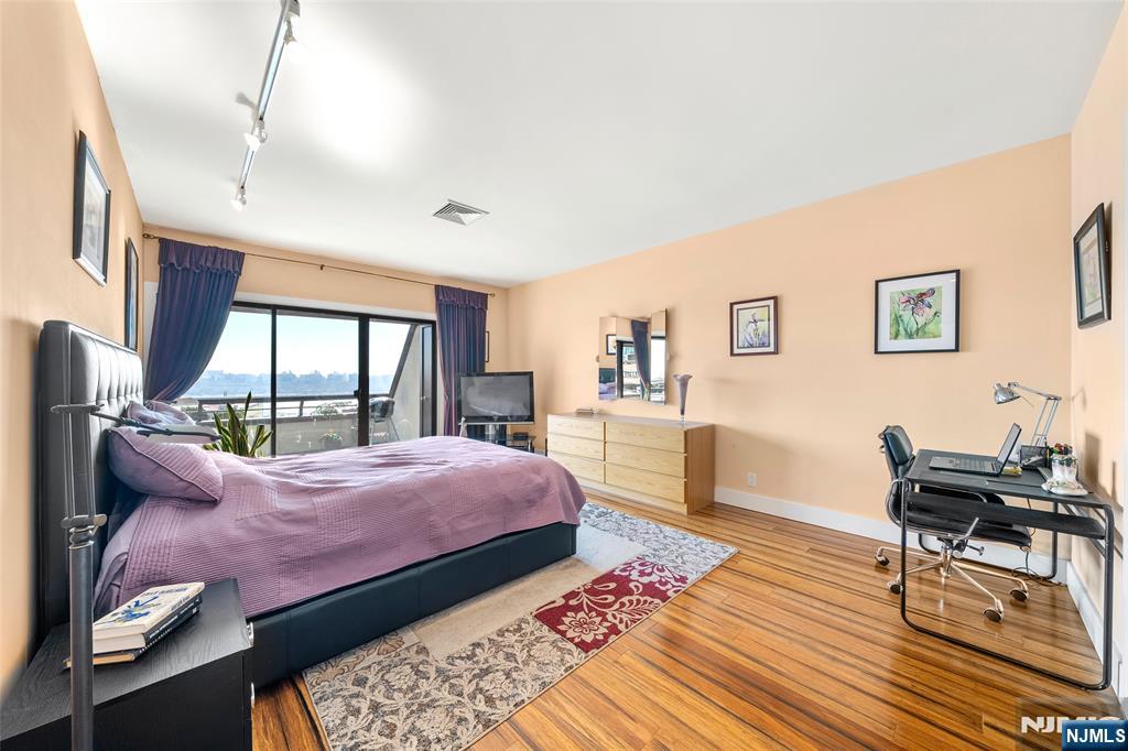 300 Gorge Road, Unit 58 Cliffside Park, NJ 07010 - Photo 19 of 32 a bedroom with a bed a large window with table and chair