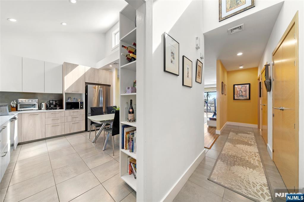 300 Gorge Road, Unit 58 Cliffside Park, NJ 07010 - Photo 7 of 32 a kitchen with stainless steel appliances kitchen island granite countertop a refrigerator and cabinets