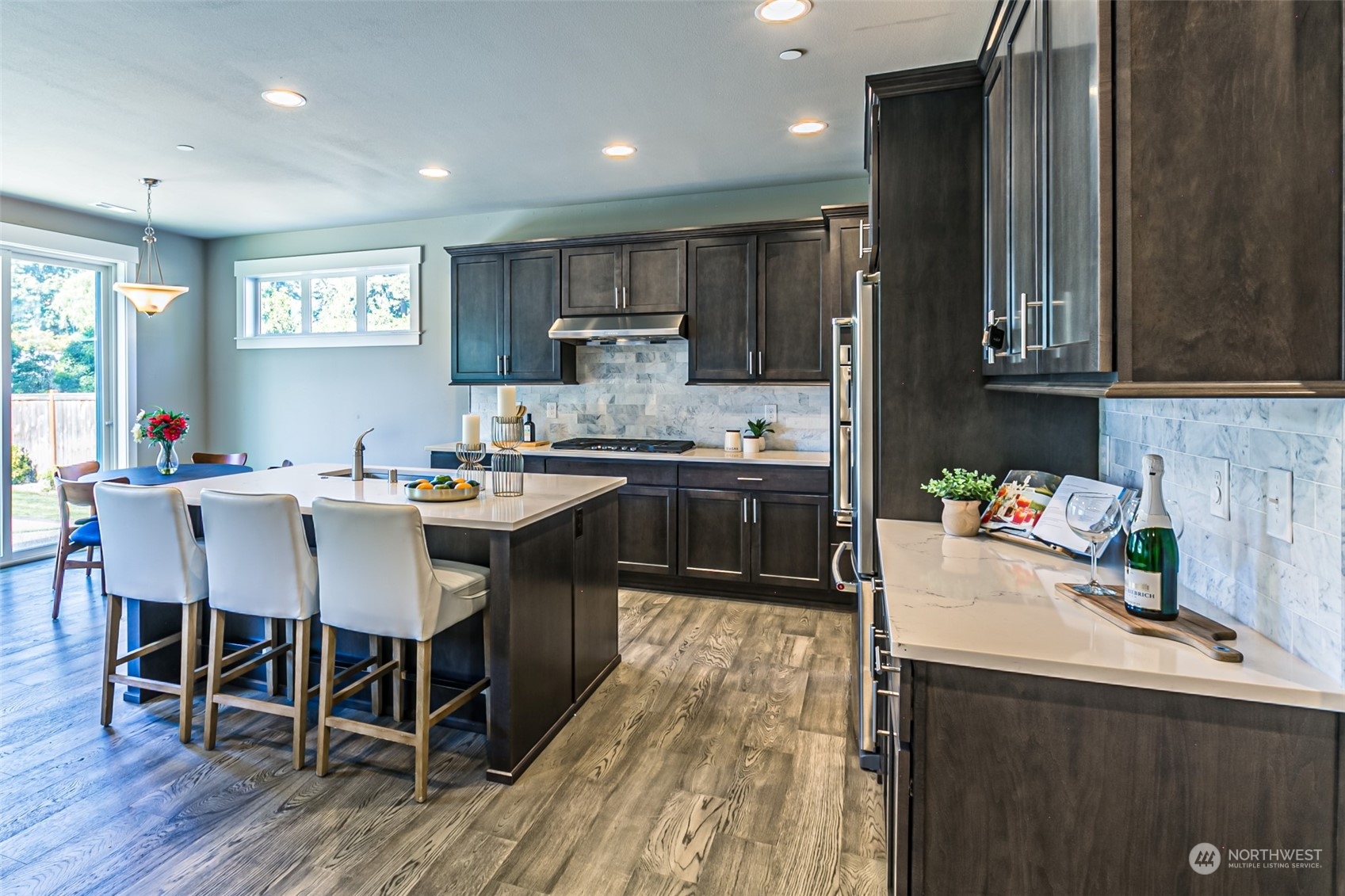 4918 Northeast 1st Street Renton, WA 98059 - Photo 8 of 40 a kitchen with a sink chairs and wooden floor