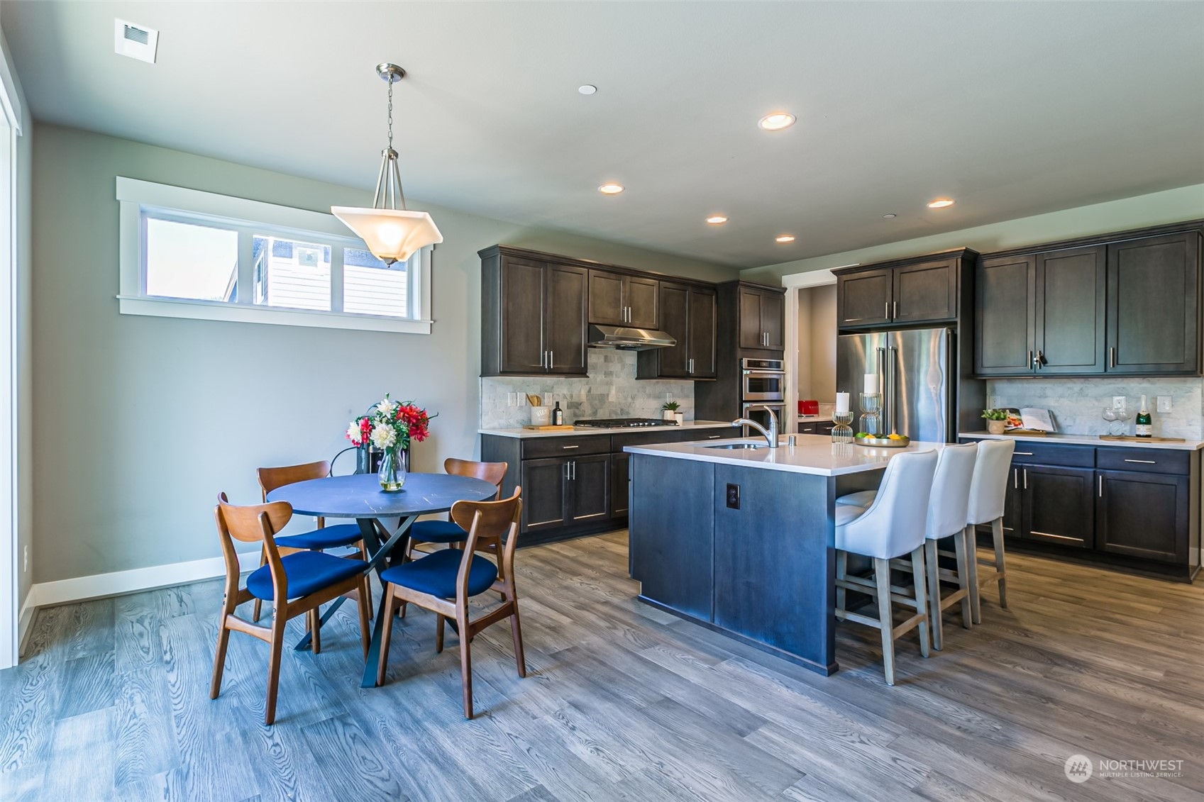 4918 Northeast 1st Street Renton, WA 98059 - Photo 10 of 40 a kitchen with granite countertop stainless steel appliances refrigerator dining table and chairs