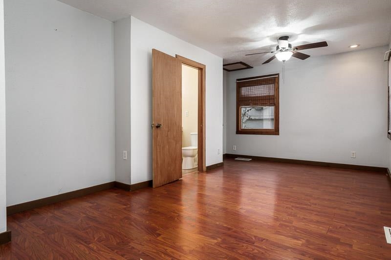 207 River Park Road Loves Park, IL 61111 - Photo 17 of 41 an empty room with wooden floor chandelier fan and windows