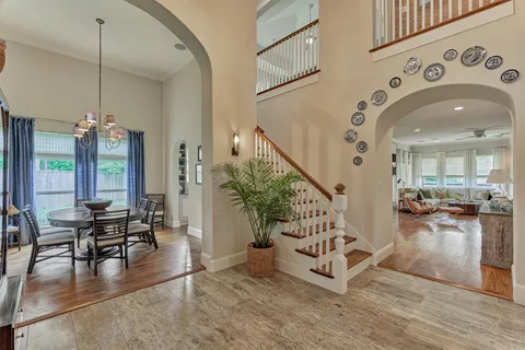 a view of a hallway with wooden floor and a living room