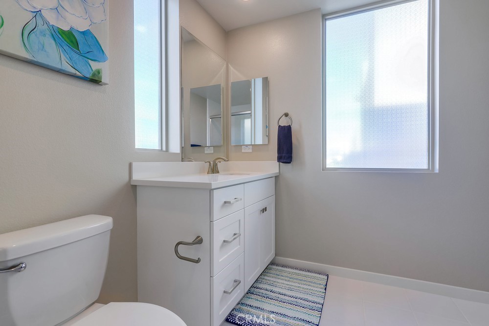 136 Tribeca Irvine, CA 92612 - Photo 44 of 70 a bathroom with a toilet sink and mirror