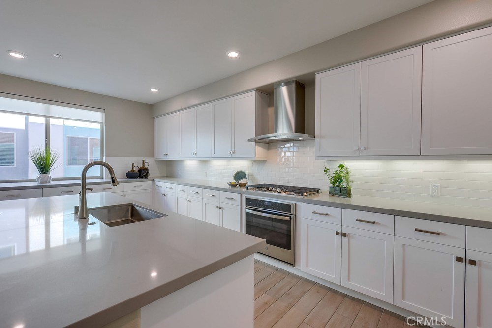136 Tribeca Irvine, CA 92612 - Photo 6 of 70 a kitchen with white cabinets a sink and dishwasher