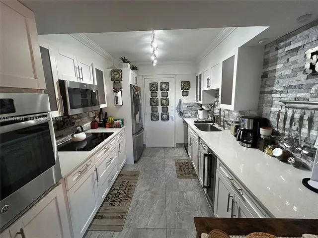 a kitchen with stainless steel appliances a sink stove and refrigerator