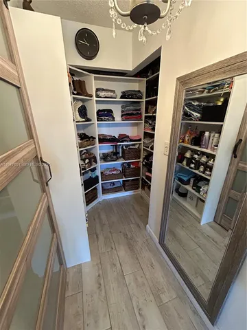 a view of walk in closet with clothes and shoes