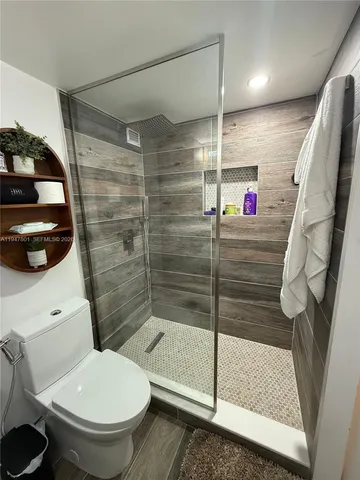 a bathroom with a toilet and a shower