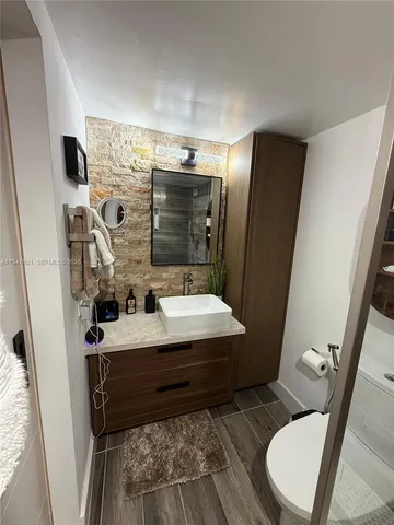 a bathroom with a sink a toilet and mirror