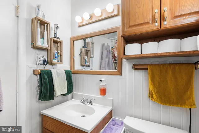 a bathroom with a sink vanity mirror and toilet