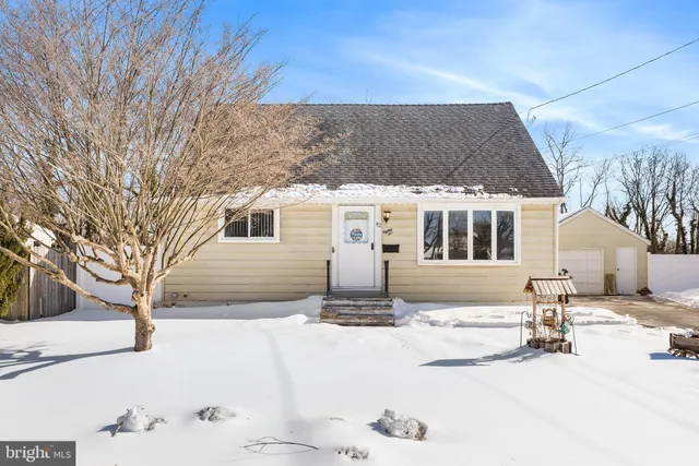 a white house that has a tree in front of it