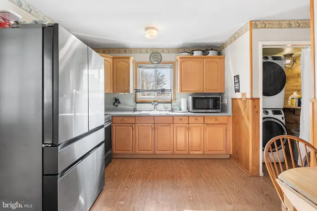 a kitchen with stainless steel appliances granite countertop a refrigerator sink and white cabinets