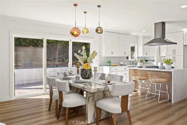 a view of a dining room with furniture a fireplace and wooden floor