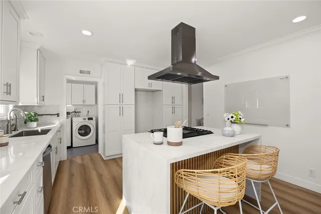 a kitchen with stainless steel appliances a dining table chairs and white cabinets