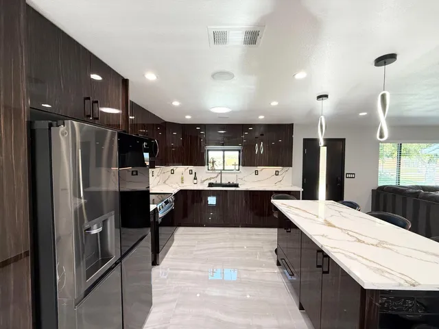 a kitchen with kitchen island granite countertop a sink and a stove