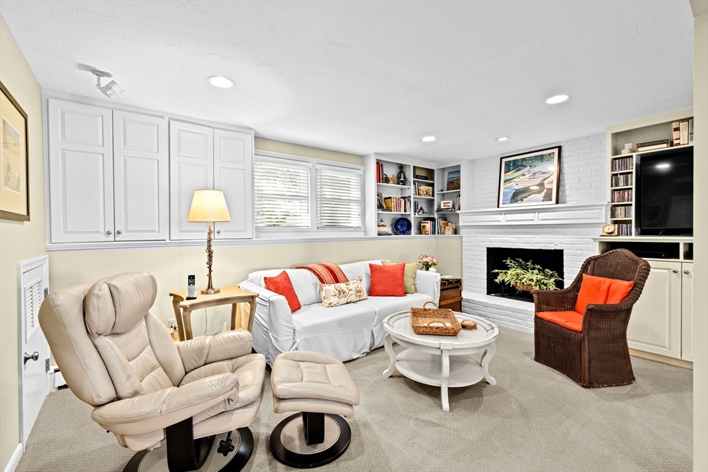 14 Aberdeen Drive Scituate, MA 02066 - Photo 23 of 42 a living room with furniture a fireplace and a flat screen tv