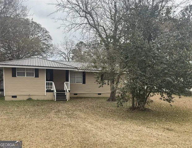 a view of a house with a yard and wooden fence