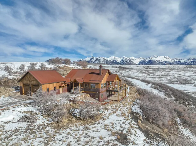 an aerial view of a house with yard and ocean view