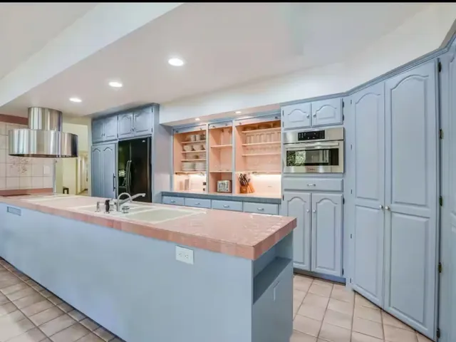 a view of kitchen with stainless steel appliances wooden floor and refrigerator