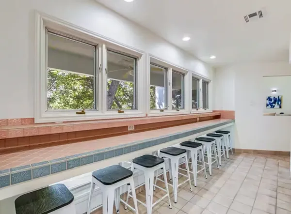 a dining room with furniture and a floor to ceiling window