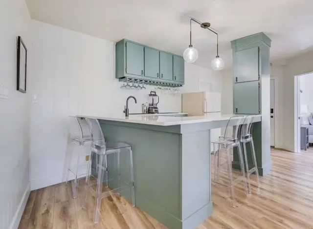 a kitchen with a table chairs sink and cabinets