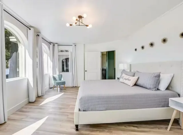 a bedroom with a large bed and a chandelier