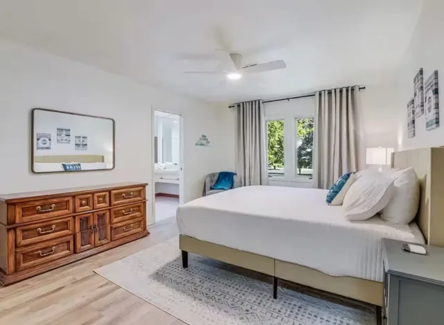 a bedroom with a bed painting on wall and a window