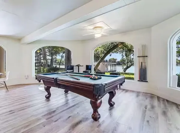 a room with pool table and windows