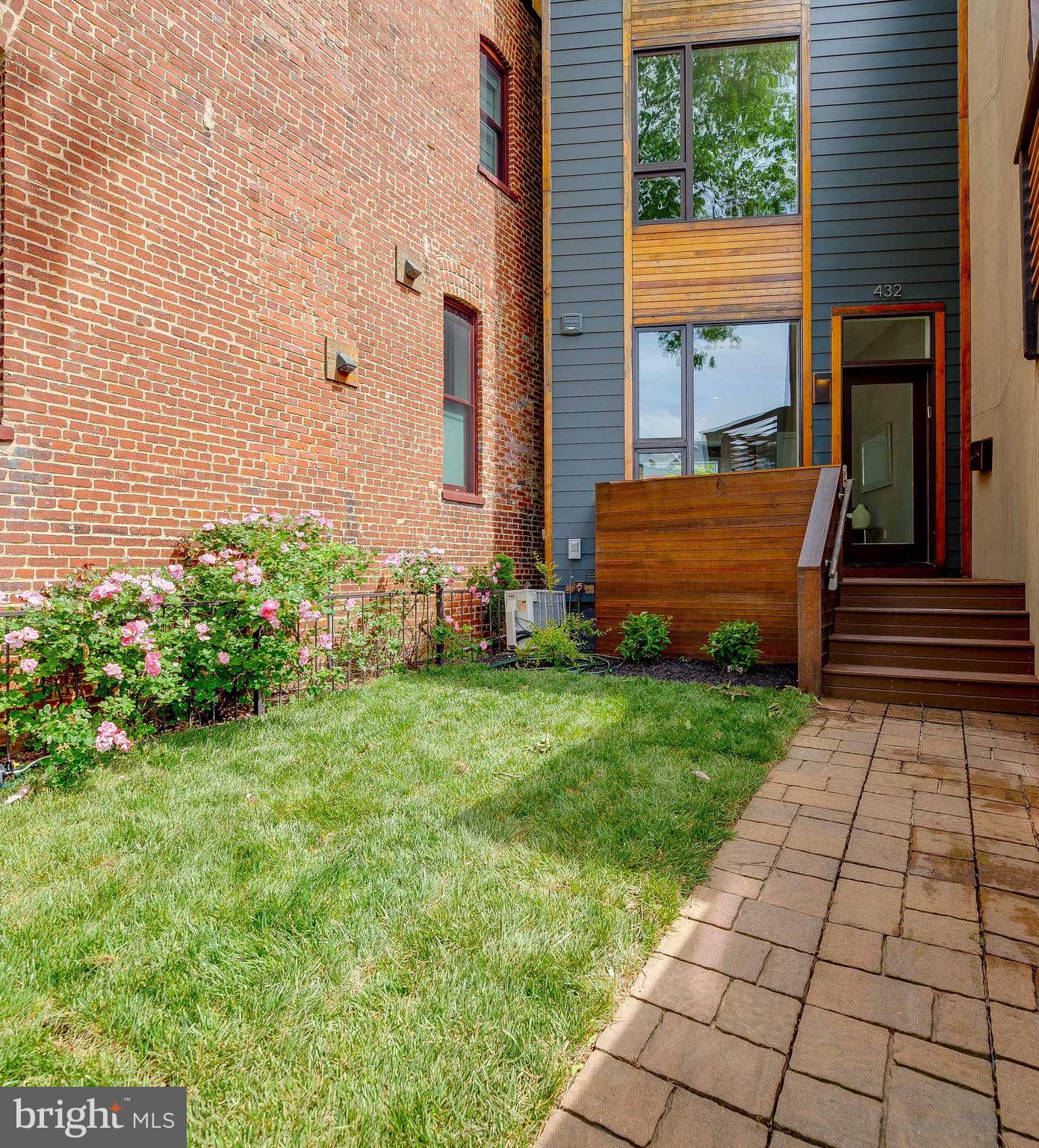 a view of a backyard with plants and brick walls
