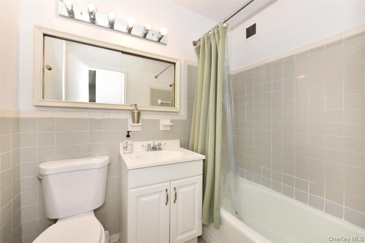 175-20 Wexford Terrace, Unit 16L Queens, NY 11432 - Photo 11 of 26 a bathroom with a sink a toilet and shower