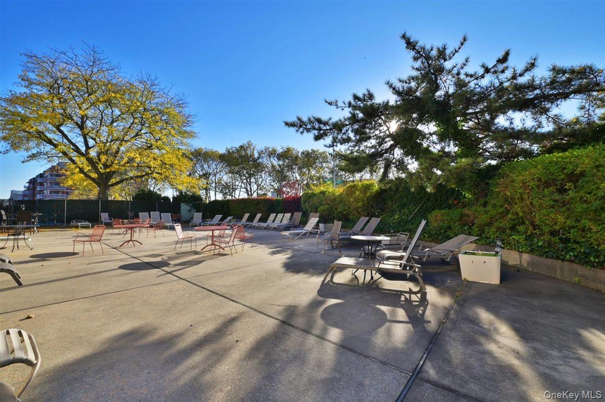 175-20 Wexford Terrace, Unit 16L Queens, NY 11432 - Photo 17 of 26 a view of a patio with dining table and chairs with a fire pit